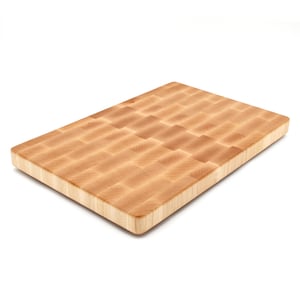 A wooden cutting board with a light-colored, natural wood grain texture.