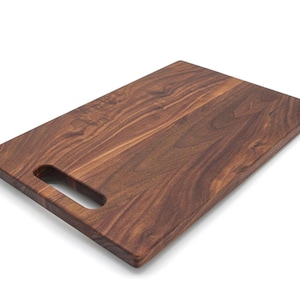 A wooden cutting board with a natural wood grain texture and a rectangular shape.