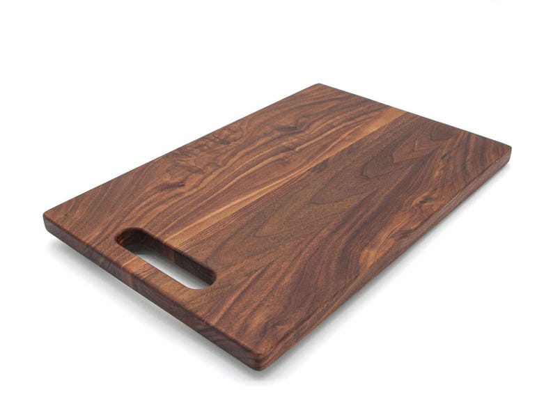 A wooden cutting board with a natural wood grain texture and a rectangular shape.