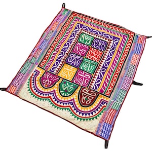 May include: A colorful, hand-stitched tapestry with geometric patterns in shades of red, purple, green, yellow, and blue. The tapestry has a white background and is framed by a red border.