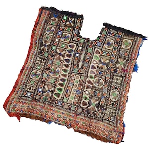 May include: A vintage, intricately embroidered textile with a square neckline. The garment features a complex pattern of geometric shapes, mirrors, and colourful beads in shades of brown, red, green, and blue. The edges are trimmed with red fabric and blue tassels.