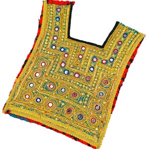May include: A square-shaped textile panel featuring a square neckline, heavily embellished with gold-colored metallic thread embroidery, sequins, and small circular mirrors. The base fabric is teal with red and black patterned borders.