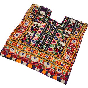 May include: A colorful embroidered fabric panel with intricate geometric patterns and floral motifs in shades of red, yellow, blue, green, and black. The fabric is likely intended for use as a decorative element or for crafting.