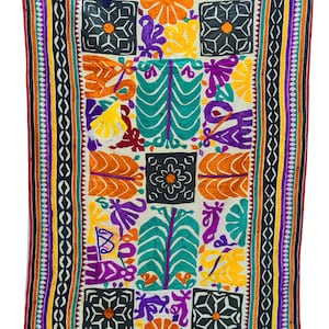 May include: A colorful embroidered tapestry with a white background and a geometric pattern. The tapestry features a variety of colors, including red, orange, yellow, green, blue, purple, and black.
