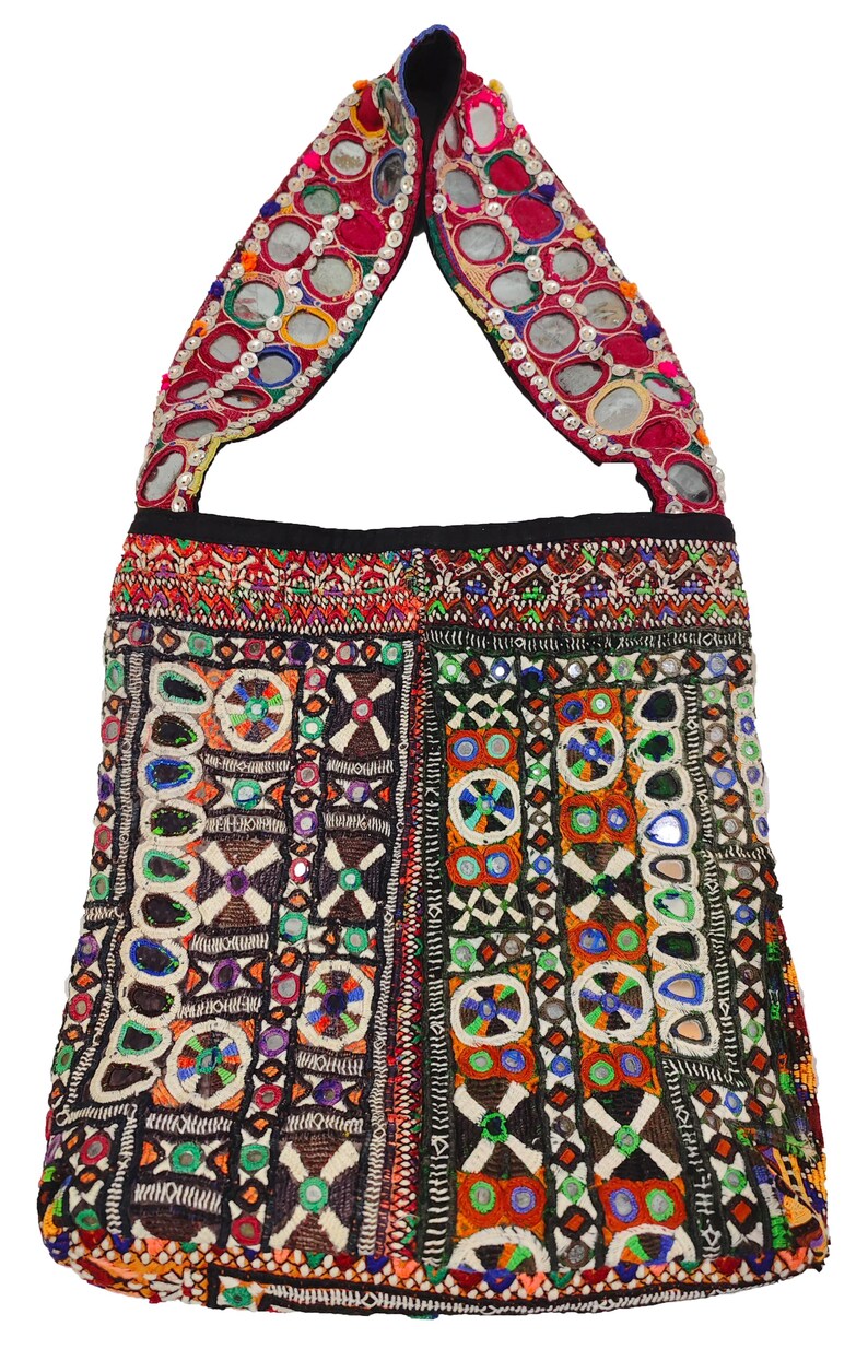 K&ouml;nnte beinhalten: Bunte, bestickte Tragetasche mit Schulterriemen. Die Tasche weist aufwendige Perlenarbeiten in verschiedenen Farben auf, darunter Rot, Blau, Gr&uuml;n und Orange. Der Riemen ist mit kleinen, runden Spiegeln verziert. Das Design der Tasche ist geometrisch und ethnisch.