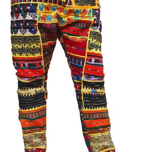 May include: Patchwork trousers in a vibrant array of colours, with a yellow waistband and trim. The design incorporates various patterns, including geometric and floral motifs, in shades of red, black, and blue. The trousers are a unique fashion item.