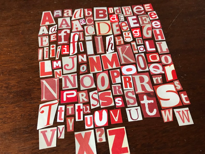 Puede incluir: Una colecci&oacute;n de letras del alfabeto de papel rojo y blanco, recortadas de revistas o peri&oacute;dicos. Las letras est&aacute;n dispuestas en un orden aleatorio, con algunas letras que aparecen varias veces.