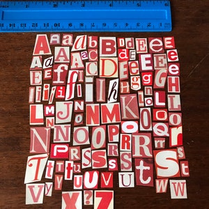 Puede incluir: Una colecci&oacute;n de recortes de letras rojas y blancas, incluyendo el alfabeto de la A a la Z. Las letras est&aacute;n dispuestas en un orden aleatorio, con algunas letras que aparecen varias veces.