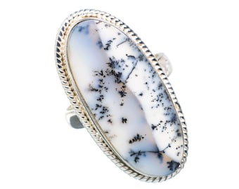 May include: A silver ring with a white and black dendritic agate oval stone.