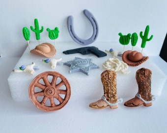Puede incluir: Un conjunto de 10 adornos para pasteles con temática de vaquero, que incluye una placa de sheriff, una herradura, una rueda de carro, dos pares de botas de vaquero y varios cactus. Los adornos están hechos de fondant y son perfectos para decorar un pastel con temática de vaquero.