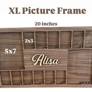 Peut inclure: Cadre photo XL en bois, mesurant 51 cm de large et 30,5 cm de haut. Il comporte plusieurs emplacements pour photos, dont des formats 5x7 et 2x3, et des espaces pour 12 petites photos. Le cadre comprend le nom "Alisa" et le mot "GRAD".