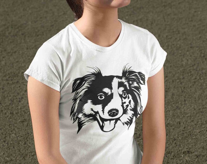 May include: A white t-shirt with a black and white illustration of a dog's head. The dog has floppy ears and a happy expression.