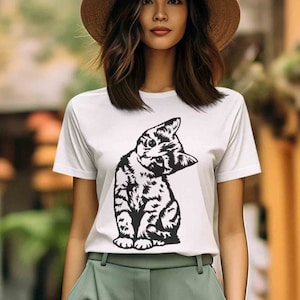 May include: A white t-shirt with a black and white illustration of a cat looking over its shoulder.
