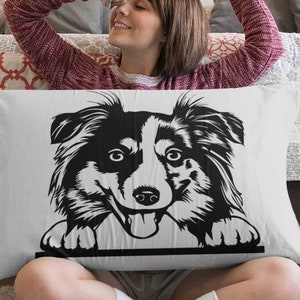 May include: A white pillow with a black and white illustration of a border collie dog peeking over the top. The dog has a playful expression and is looking directly at the viewer.