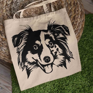 May include: A beige tote bag with a black and white silhouette of a dog's head. The dog has floppy ears and a happy expression.