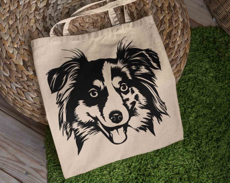 May include: A beige tote bag with a black and white silhouette of a dog's head. The dog has floppy ears and a happy expression.