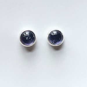 Peut inclure: Une paire de boucles d'oreilles en argent avec des pierres rondes de couleur violet foncé.