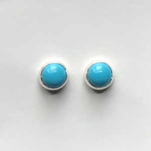 May include: A pair of silver stud earrings with round turquoise stones.