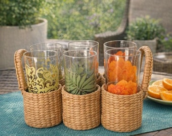 Juego de 7 vasos altos de cristal con diseño gráfico de Pottery Barn y soporte de mimbre para 6 vasos.