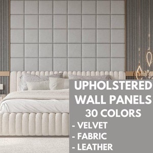 May include: A white upholstered bed with a headboard and footboard featuring a tufted design. The bed is in front of a wall with gray upholstered wall panels. The text "Upholstered Wall Panels 30 Colors - Velvet - Fabric - Leather" is displayed on the wall.