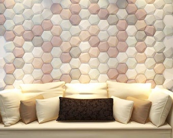 May include: A white couch with multiple pillows in various shades of brown and beige, set against a wall covered in a geometric pattern of hexagonal tiles in shades of pink, white, and gray.