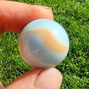 Może przedstawiać: Szklana kulka w kolorze niebieskim i pomarańczowym.