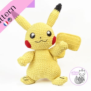 May include: A crocheted yellow Pikachu plush toy with black ears and a red cheek. The toy is standing on a white surface.