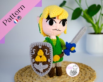 May include: A crocheted Link from the Legend of Zelda video game series. He is wearing a green tunic, brown pants, and a brown belt. He is holding a blue and silver sword and a brown shield with the Triforce symbol on it. The pattern is available for purchase.