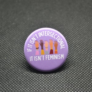 May include: Purple button with the text "If it isn't intersectional it isn't feminism". The button features a graphic of five hands of different skin tones raised in the air.