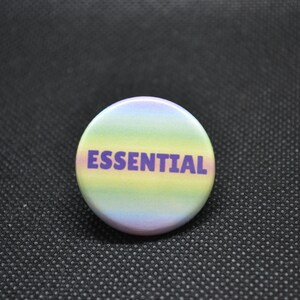 May include: A round button with a rainbow gradient background and the word "ESSENTIAL" in purple text.