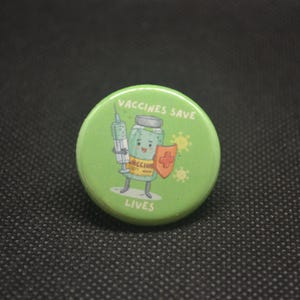May include: Green button with a cartoon illustration of a vaccine vial with a syringe and the text "Vaccines Save Lives".