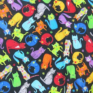May include: A black fabric covered in a repeating pattern of colorful cartoon cats. The cats are in various poses and colors, including red, yellow, blue, green, orange, and purple. Small paw prints are scattered throughout the design.