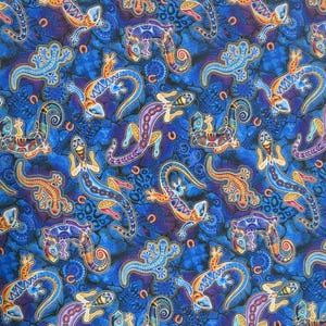 May include: A vibrant fabric featuring a repeating pattern of stylized lizards in shades of blue, purple, orange, and yellow. The lizards are set against a textured blue background with horseshoe and dot motifs.