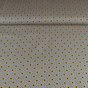 May include: A roll of fabric featuring a repeating pattern of yellow sunflowers with black centers and green leaves on a gray background. The fabric has a small, checkered design between the flowers.
