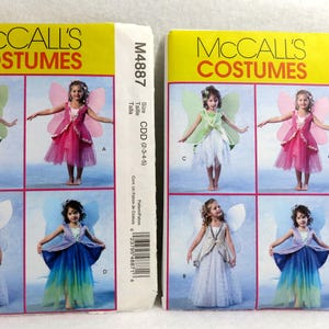May include: Two McCall's Costumes sewing pattern packages. The packages show children in fairy costumes with wings. The text "MCCALL'S COSTUMES" is printed in large letters. One package is size CDD (2-3-4-5), the other is size CL (6-7-8).