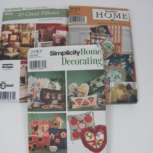 Könnte beinhalten: Eine Sammlung von Simplicity Home Decorating Schnittmustern. Die Muster zeigen Designs für Kissen, mit Titeln wie "10 Great Pillows" und "Design Your Own Pillows". Die Cover zeigen verschiedene Kissenstile, darunter Blumen-, Herz- und Apfeldesigns.