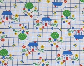 Tissu en coton imprimé fantaisie vintage pour enfants, représentant de petites maisons de campagne, des arbres et des fleurs sur fond blanc avec un quadrillage bleu.