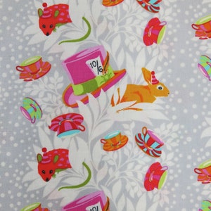 May include: A white fabric with a repeating pattern of teacups, rabbits, and mice. The teacups are in various colors and patterns, including pink, blue, and green. The rabbits are orange and have a party hat on their heads. The mice are red and have a party hat on their heads. The fabric also has a repeating pattern of green leaves and white dots.