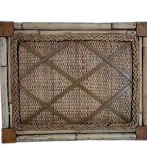 May include: A rectangular memo board featuring a woven rattan center panel with a crisscross ribbon pattern. The board is framed by light-colored bamboo poles and finished with a braided rattan border and square corner accents in a darker brown.