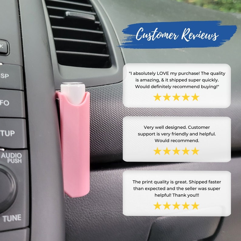 May include: A pink car air freshener hanging from the air vent in a car. The air freshener is a small, rectangular shape with a white top. The image includes customer reviews with five-star ratings.