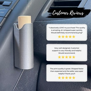 Op de afbeelding: Een 3D-geprinte autotelefoonhouder met een beige telefoonhoesje erin. De houder is bevestigd aan het dashboard van een auto. De afbeelding bevat klantbeoordelingen met vijfsterrenbeoordelingen.