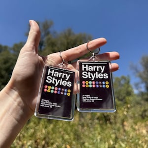 May include: Two rectangular clear acrylic keychains featuring a black background with white text that reads Harry Styles, Together, 30 Nights, New York City 2026, Madison Square Garden with Jamie XX, and colorful circular icons below the name.