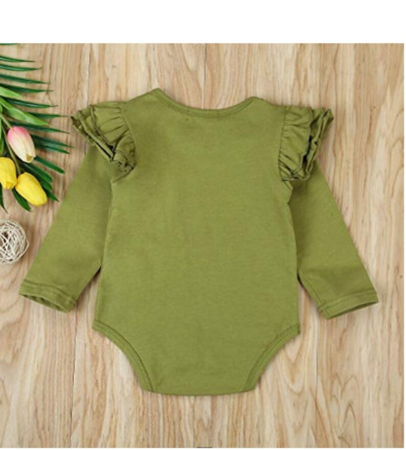 Op de afbeelding: Een groene baby romper met lange mouwen en geruite mouwen.