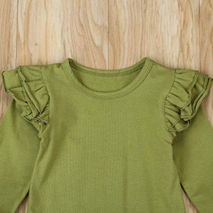 Op de afbeelding: Een lang mouwig groen shirt met geruite mouwen. Het shirt heeft een ronde hals.