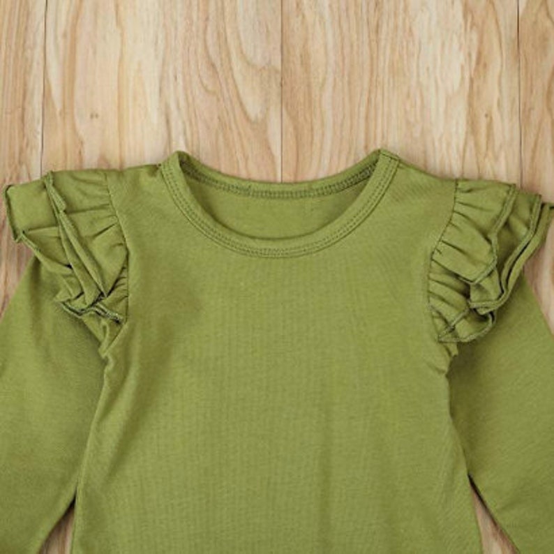 Op de afbeelding: Een lang mouwig groen shirt met geruite mouwen. Het shirt heeft een ronde hals.