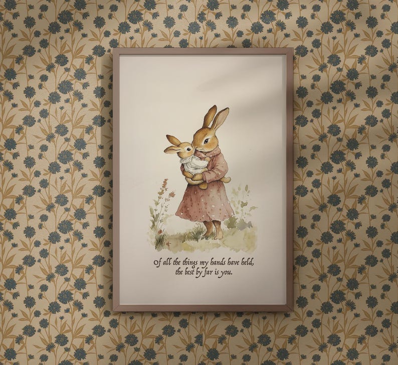 May include: Framed watercolor print featuring two rabbits. One rabbit is holding a smaller rabbit. The larger rabbit wears a pink dress. The print includes the text: "Of all the things my hands have held, the best by far is you."