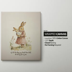 May include: Wrapped canvas art featuring a watercolor illustration of two rabbits. One rabbit is holding a smaller rabbit. The larger rabbit wears a pink dress. Text on the canvas reads, "Of all the things my hands have held, the best by far is you."