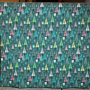 Puede incluir: Una tela de color verde azulado con un patr&oacute;n repetido de &aacute;rboles de Navidad estilizados en varios colores, incluyendo rosa, verde, amarillo y blanco. Los &aacute;rboles est&aacute;n decorados con estrellas y peque&ntilde;as cajas de regalo.