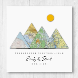 Könnte beinhalten: Ein weißer Hintergrund mit drei Bergen aus Karten, einer gelben Sonne über den Bergen und dem Text "Adventuring Together Since Emily & David EST. 2020"