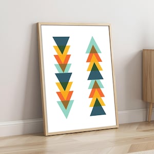 May include: A framed wall art print featuring two vertical columns of stacked triangles in shades of dark blue, mustard yellow, orange, and light teal. The triangles are arranged in alternating patterns against a plain white background.
